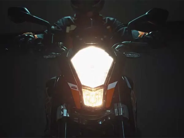 faro de una KTM Duke circulando de noche con las luces encendidas durante una ruta